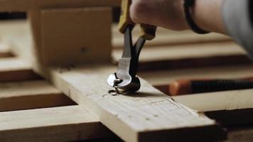 ijzeren tang bijt een spijker af in een houten plank video