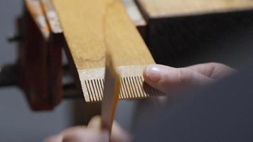 wood craftsman grinds teeth on a wooden comb