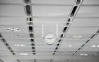 Hanging white clock at the big train station photo