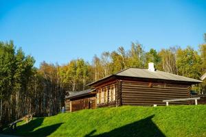 Wooden building on the background of a birch grove. photo