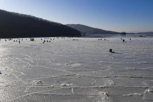 Vista aérea de la bahía en el hielo con pescadores de pesca de invierno. foto