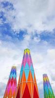 the colorful conical roof facade in the carnival land. tourist attraction building against the cloudy sky. the tourist attraction with cheerful nuance.