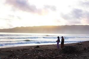 Indonesia 2021. una pareja jugando en la playa a la hora del atardecer foto