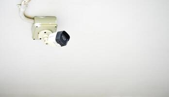 CCTV camera on the white ceiling shot as object on copy space background photo