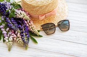 Straw hat and lupine flowers photo