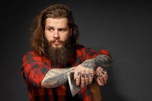 handsome man with long hair with an ax in his hands on a dark studio background photo