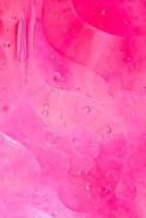 foto de aceite en una superficie de agua con burbujas de color rosa suave. fondo colorido abstracto.