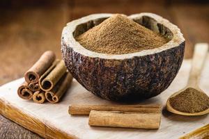 powdered cinnamon and stick, in a rustic wooden bowl, exotic cinnamon from Brazil. photo