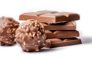El enfoque selectivo de barras de chocolate con bolas de chocolate en primer plano foto