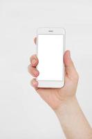 Hand holding white cellphone isolated on white clipping path inside. Online shopping. Top view. Mock up. Copy space. Template.Blank. photo