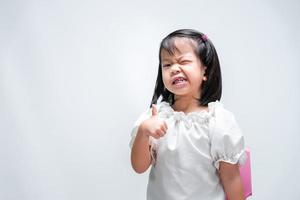 Asian girl thumbs up. Child showed that it was great. Children smile sweetly. photo