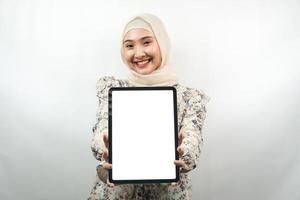 Hermosa joven mujer de negocios musulmana asiática confiada y sonriente, manos sosteniendo tableta con pantalla blanca o pantalla en blanco, presentando algo, presentando un producto, presentando un informe, aislado