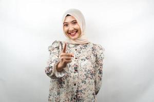 Beautiful young asian muslim woman smiling confident and cheerful, with hands pointing at camera, pointing at audience, pointing to customer, isolated on white background
