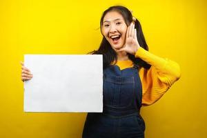 Pretty and cute young woman cheerful holding blank empty banner, placard, white board, blank sign board, white advertisement board, presenting something in copy space, promotion photo