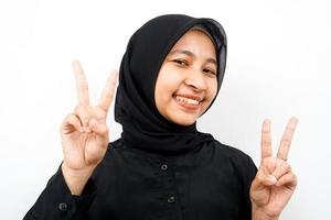 Closeup of beautiful young Muslim woman, smiling with two fingers, victory, isolated photo