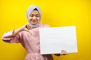 Bastante joven mujer musulmana no le gusta, mano sosteniendo pancarta vacía en blanco, cartel, tablero blanco, tablero de letrero en blanco, tablero de anuncio blanco, presentando algo en el espacio de la copia, promoción