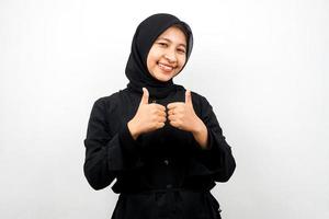 Beautiful young asian muslim woman with hands thumbs up, ok sign, good job, success, victory, smiling confident, enthusiastic and cheerful, looking at camera isolated on white background photo