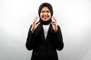 Beautiful young asian muslim business woman shocked, dizzy, stressed, unhappy, many problems, want solution, with hands up isolated on white background photo