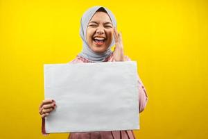 Pretty young muslim woman cheerful holding blank empty banner, placard, white board, blank sign board, white advertisement board, presenting something in copy space, promotion photo