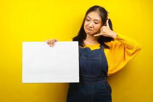 Pretty and cute young woman holding blank empty banner, placard, white board, blank sign board, white advertisement board, presenting something in copy space, promotion photo