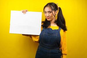 Pretty and cute young woman serious, hand holding blank empty banner, placard, white board, blank sign board, white advertisement board, presenting something in copy space, promotion photo