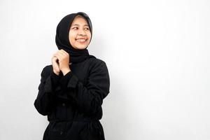 Beautiful young asian muslim woman confident and cheerful looking empty space presenting something, isolated on white background photo