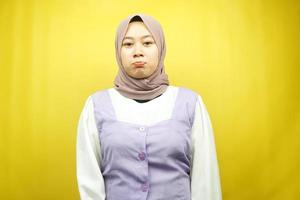 Hermosa joven musulmana asiática haciendo pucheros mirando a la cámara aislada sobre fondo amarillo foto