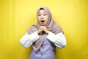 Beautiful young asian muslim woman shocked, surprised, wow expression, isolated on yellow background photo
