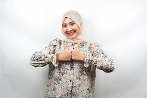 Beautiful young asian muslim woman with hands thumbs up, ok sign, good job, success, victory, smiling confident, enthusiastic and cheerful, looking at camera isolated on white background photo