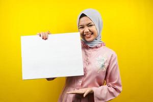 Pretty young muslim woman cheerful holding blank empty banner, placard, white board, blank sign board, white advertisement board, presenting something in copy space, promotion photo