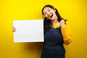 Pretty and cute young woman cheerful holding blank empty banner, placard, white board, blank sign board, white advertisement board, presenting something in copy space, promotion photo