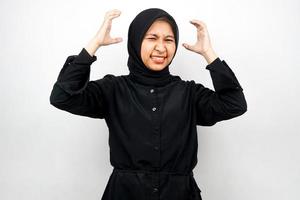 Beautiful young asian muslim woman shocked, dizzy, stressed, unhappy, many problems, want solution, with hands on head isolated on white background