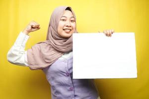 Pretty young muslim woman cheerful holding blank empty banner, placard, white board, blank sign board, white advertisement board, presenting something in copy space, promotion photo