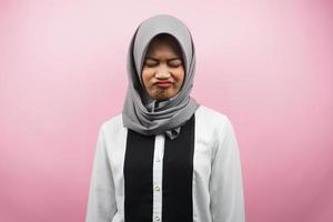 Beautiful asian young muslim woman pouting, disappointed, unhappy, dissatisfied, isolated on pink background photo