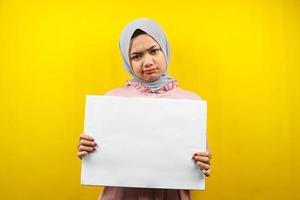 Pretty young muslim woman sad, hand holding blank empty banner, placard, white board, blank sign board, white advertisement board, presenting something in copy space, promotion