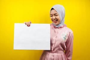 Pretty young muslim woman cheerful holding blank empty banner, placard, white board, blank sign board, white advertisement board, presenting something in copy space, promotion photo