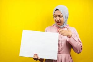 Pretty young muslim woman shocked, surprised, wow, hand holding blank empty banner, placard, white board, blank sign board, white advertisement board, presenting something in copy space, promotion