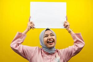 Pretty young muslim woman cheerful holding blank empty banner, placard, white board, blank sign board, white advertisement board, presenting something in copy space, promotion photo