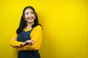 Pretty and cute young woman cheerful, confident, looking at empty space presenting something, promoting products, looking for ideas, advertising, isolated photo