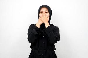 Beautiful young asian muslim woman shocked, surprised, disbelieving, getting shocking information, with hands covering mouth isolated on white background photo