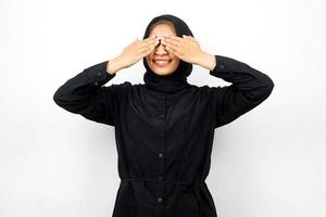 Beautiful young asian muslim woman with hands closing eyes, isolated on white background photo
