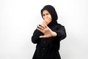 Beautiful young asian muslim woman with hand covering mouth, refusing something isolated on white background photo