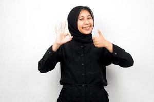 Hermosa y alegre joven musulmana asiática, pulgar hacia arriba, signo de ok, buen trabajo, victoria, aislado sobre fondo blanco.
