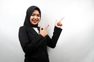 Beautiful young asian muslim business woman smiling confident, enthusiastic and cheerful with hands pointing  empty space presenting something facing camera isolated on white background photo