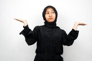 Beautiful young asian muslim woman with hands presenting something on empty space isolated on white background photo