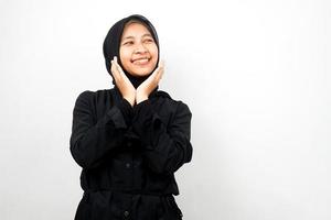 Beautiful young asian muslim woman smiling confident, enthusiastic and cheerful with hands V sign on chin isolated on white background photo