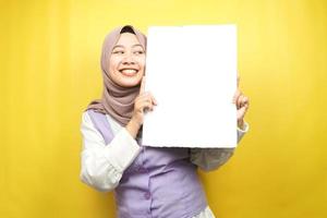 Pretty young muslim woman cheerful holding blank empty banner, placard, white board, blank sign board, white advertisement board, presenting something in copy space, promotion photo