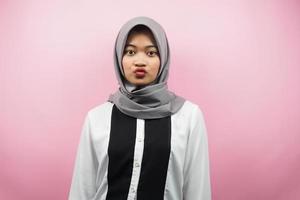Joven y bella mujer musulmana asiática se hace agua la boca, conmocionada, sorprendida, con los ojos bien abiertos, aislado sobre fondo rosa foto