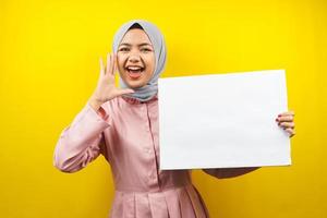 Pretty young muslim woman cheerful holding blank empty banner, placard, white board, blank sign board, white advertisement board, presenting something in copy space, promotion photo