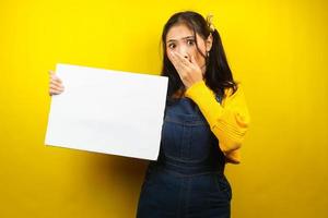 Pretty and cute young woman surprised, shocked, wow, hand holding blank empty banner, placard, white board, blank sign board, white advertisement board, presenting something in copy space, promotion photo